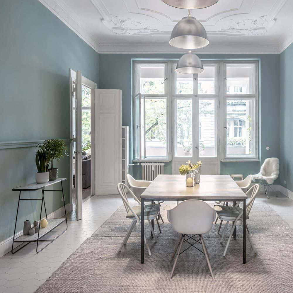 Esszimmer im denkmalgeschützten Altbremer Haus mit restauriertem Deckenstuck und blau gestrichenen Wänden