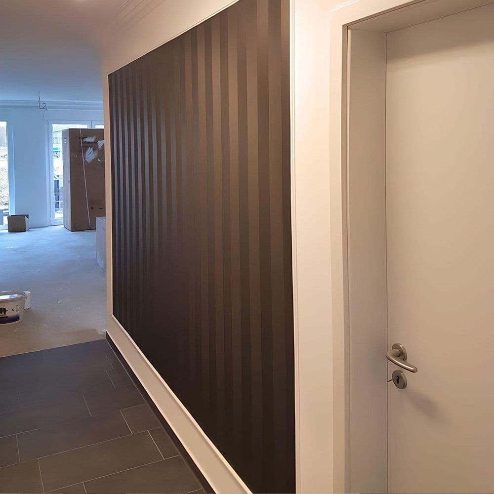 Flur im Altbau mit schwarzer Streifen-Effekttapete als Akzentwand, eingefasst mit weißen Wandleisten