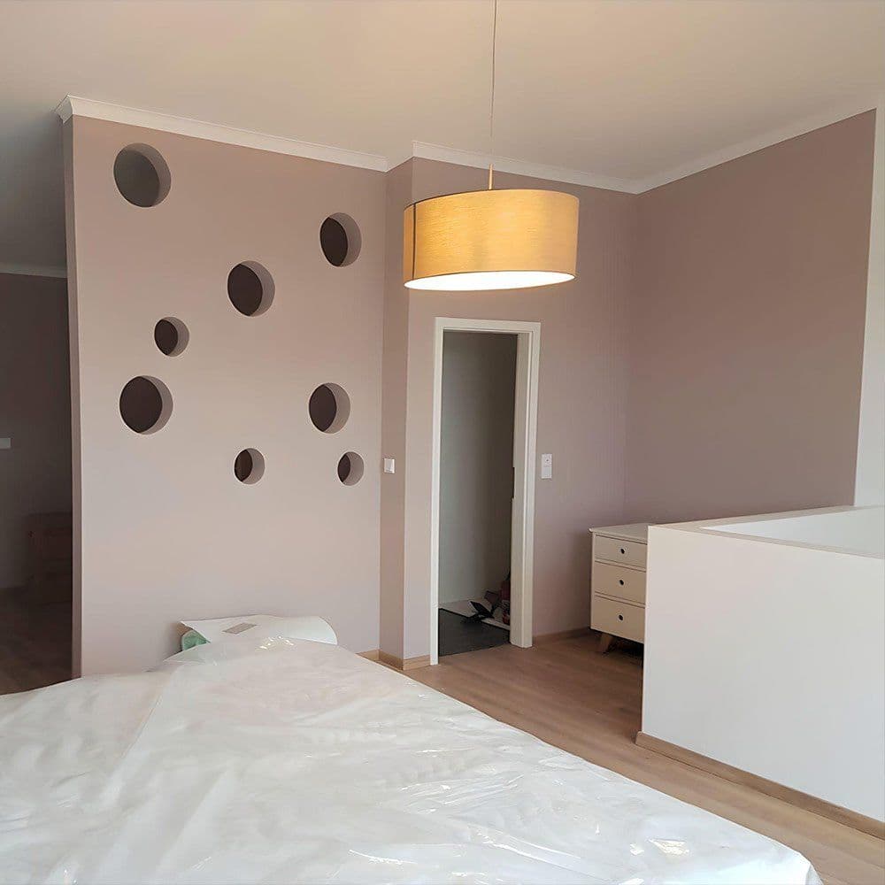 Schlafzimmer mit Trockenbauwand mit runden Ausschnitten, abgestimmten Wandfarben und Parkettboden